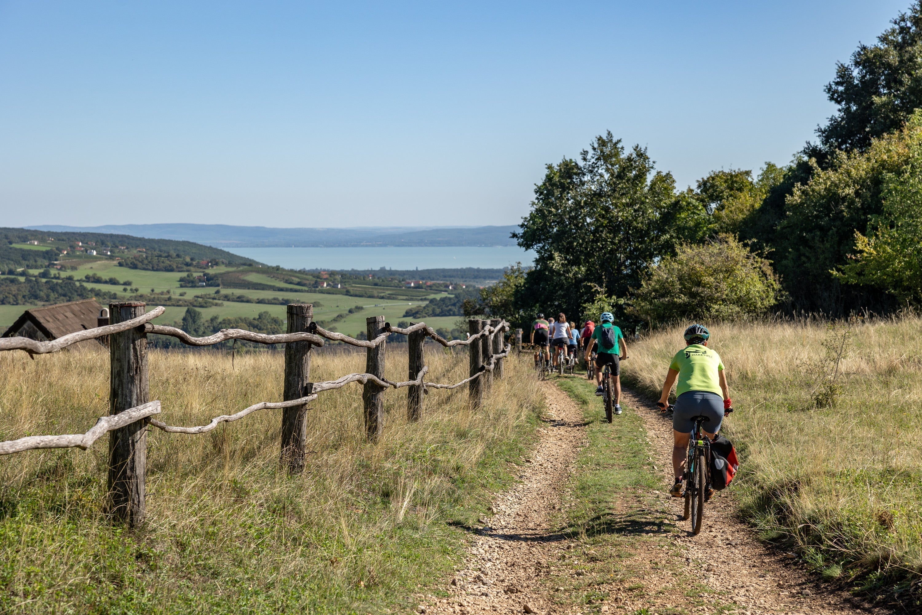 Bikepackers descent on a dirtroad towards lake Balaton